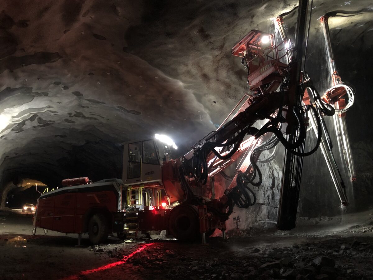 Bergarbeten pågår med stort fordon i tunnel.