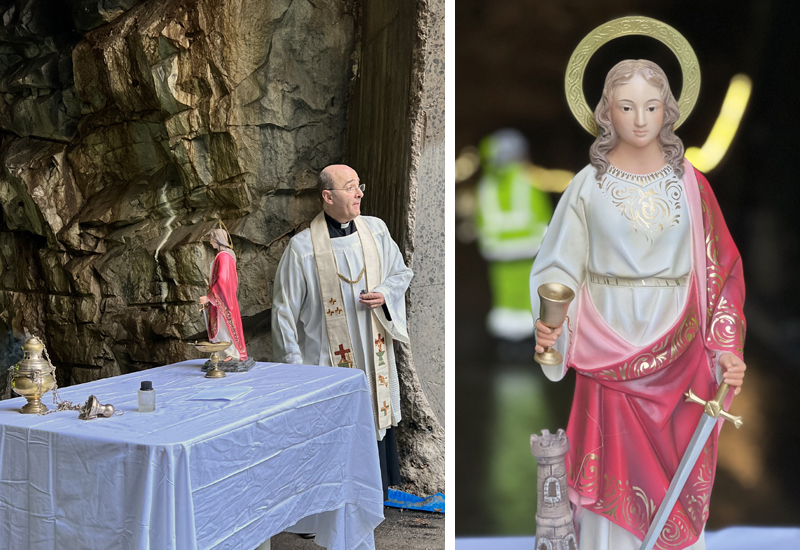 Präst vid ett bord med staty av helgonet Sankta Barbara.