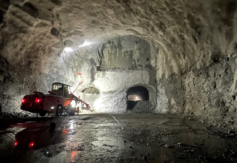 En maskin står i ena änden av en tunnel framför två mindre öppningar.