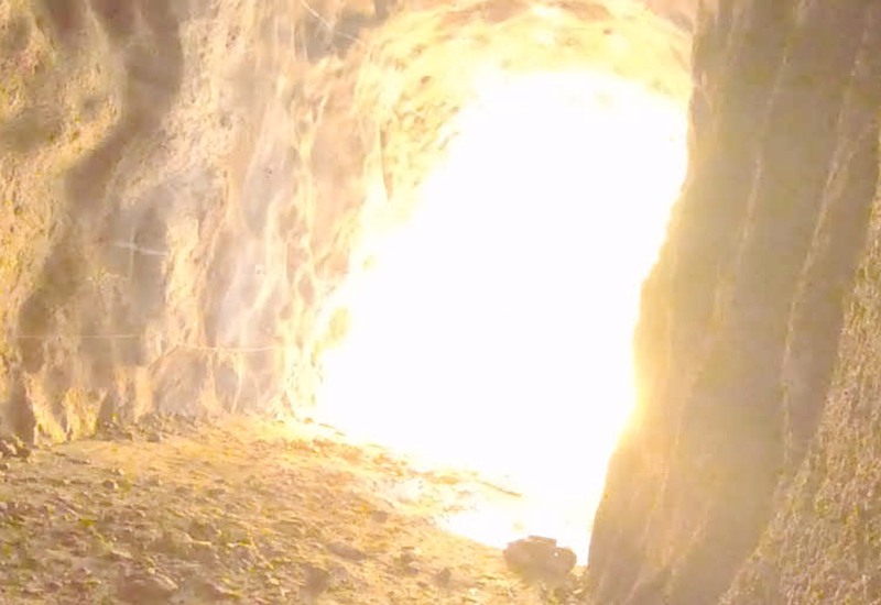 Ett starkt ljus från en sprängning lyser upp en tunnel.