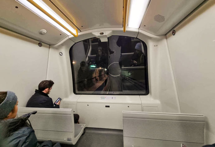 Vy inifrån ett självkörande tåg där en tunnel syns i fönstret.