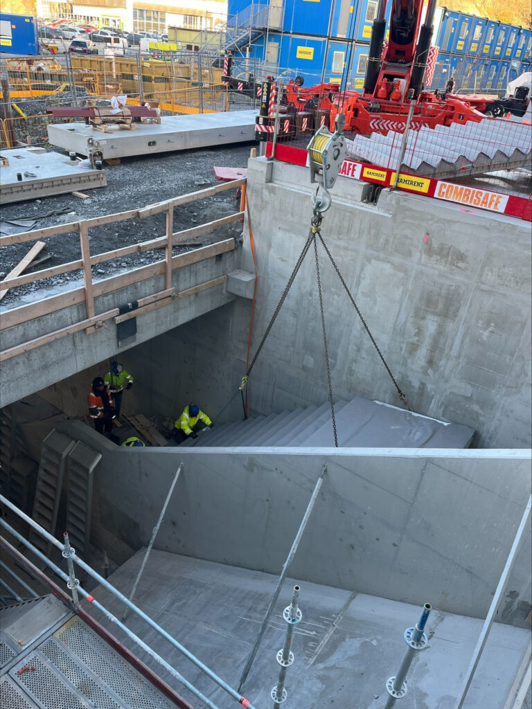 Här lyfts en färdig betongtrappa på plats i Sickla.