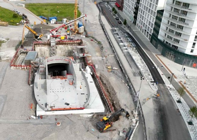 Byggarbetsplats med flera byggkranar runt en betongkonstruktion. och en