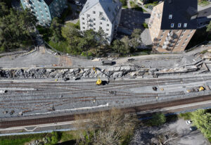 Drönarbild över arbetsområdet söder om Hökarängens station. På bilden pågår spårarbeten.