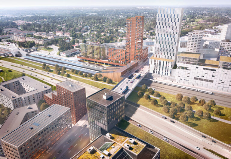 Flygvy mot Veddesta med Barkarby pendeltågsstation, Mälarbanans tågspår, E18 och kommande bebyggelse. En ny stationsbyggnad och bussterminal vid Veddestabron som förbinder Veddesta med Barkarbystaden.