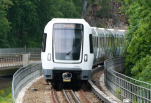 Ett vitt tunnelbanetåg kör på ett spår.