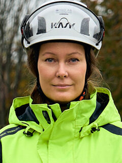 Kvinna i varseljacka och bygghjälm med visir.