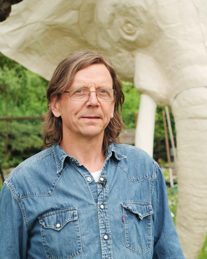 En man står framför en staty av en elefant.