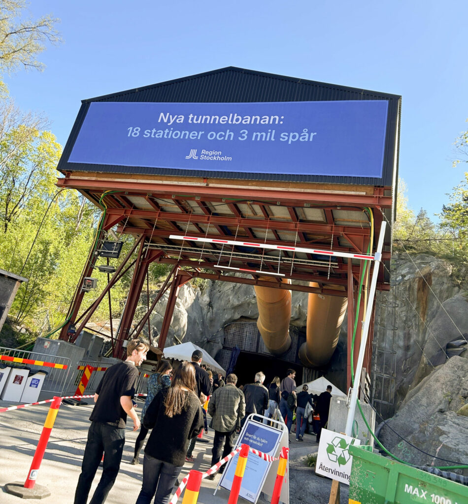 En grupp människor som står utanför en tunnel.